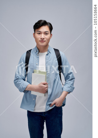 Portrait of smiling young college student with books and backpack against white background Portrait of smiling young college student with books and backpack against white background 105158664