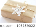 Christmas and New Year background. Gift box wrapped in kraft paper with jute cord. Decorated with a crocheted snowflake 105159022