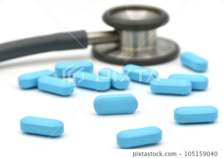 Stethoscope and blue caplet medicine on white background. Stethoscope and blue caplet medicine on white background. 105159040