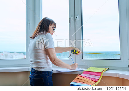 Woman measuring window with tape measure, tailoring service Woman measuring window with tape measure, tailoring service 105159554