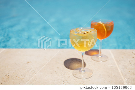 Two glass of delicious cocktails against poolside at resort hotel. Two glass of delicious cocktails against poolside at resort hotel. 105159963