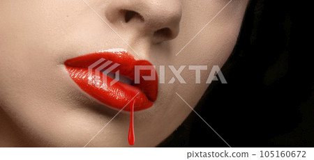 Close-up of a drop of red lipstick dripping from the girl's lips on a black background. 105160672