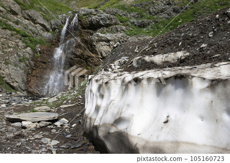 Waterfall in the mountains against the backdrop of a descended glacier. Waterfall in the mountains against the backdrop of a descended glacier. 105160723