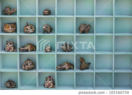 Handmade clay children's toys of fabulous animals lie in wooden cells. Handmade clay children's toys of fabulous animals lie in wooden cells. 105160739