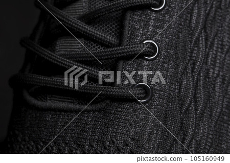 The texture of a black rag sneaker with laces close-up. The texture of a black rag sneaker with laces close-up. 105160949
