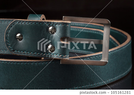 Part of a green leather belt on a black background. Part of a green leather belt on a black background. 105161281