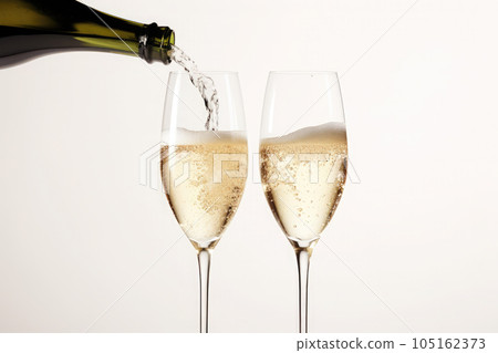 Champagne pouring from a bottle into wine glass isolated on white background 105162373