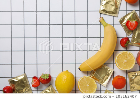 Condoms on bananas with fruit on a light background, place for text 105162407