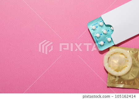 Condoms and birth control pills on a pink background, place for text Condoms and birth control pills on a pink background, place for text 105162414