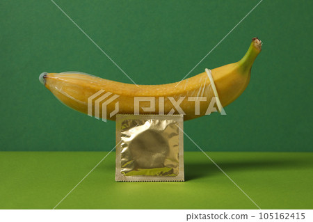 A condom on a banana on a green background A condom on a banana on a green background 105162415