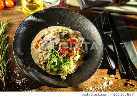 Black Angus beef tagliatelle pasta with fresh black truffles and parmegano. Delicious healthy traditional food closeup served for lunch in modern gourmet cuisine restaurant 105163697