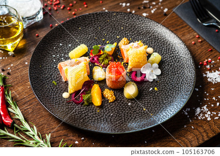 Salted Scottish salmon with trout roe. Marinated cucumber and onion, wonton chips. Delicious healthy Italian traditional food closeup served for lunch in modern gourmet cuisine restaurant 105163706