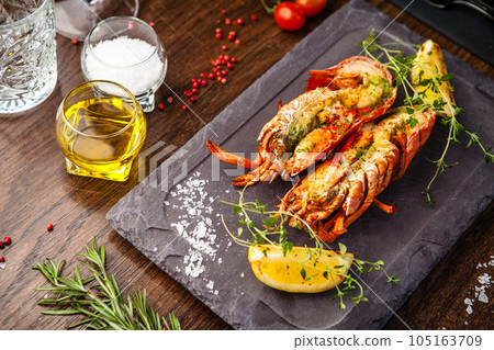 Lobster with flavored butter. Herb butter, lemon. Delicious healthy traditional food closeup served for lunch in modern gourmet cuisine restaurant Lobster with flavored butter. Herb butter, lemon. Delicious healthy traditional food closeup served for lunch in modern gourmet cuisine restaurant 105163709