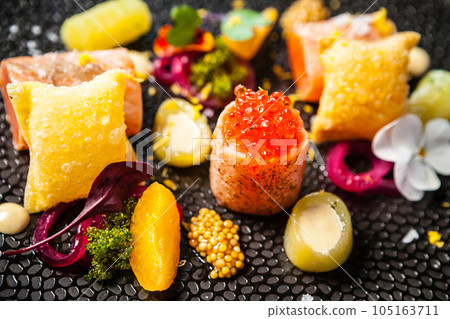 Salted Scottish salmon with trout roe. Marinated cucumber and onion, wonton chips. Delicious healthy Italian traditional food closeup served for lunch in modern gourmet cuisine restaurant 105163711