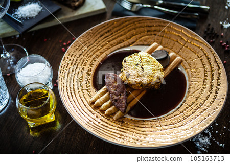 Black Angus 24 carat gold steak. Beef tenderloin, foie gras, fresh black truffle, white asparagus, port wine sauce. Delicious food closeup served for lunch in modern gourmet cuisine restaurant 105163713