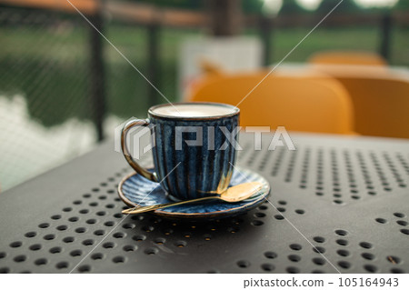 Hot coffee, milk, floral foam and aromatic coffee cups white cup is ready to serve customers in the morning, placed on a table in popular classic city coffee shop Hot coffee, milk, floral foam and aromatic coffee cups white cup is ready to serve customers in the morning, placed on a table in popular classic city coffee shop 105164943