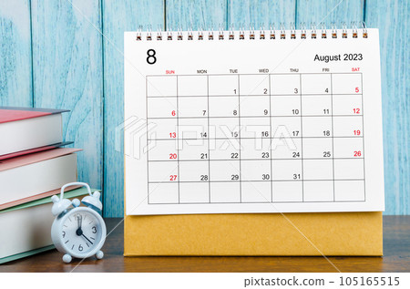 The August 2023 Monthly desk calendar for the organizer to plan 2023 year with alarm clock and books on wooden table. 105165515