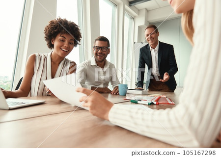 Great results Group of young business people looking at documents and smiling while sitting at the office table Great results Group of young business people looking at documents and smiling while sitting at the office table 105167298