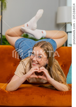 Happy young woman girl makes symbol of love showing heart sign to camera express romantic feelings 105168014
