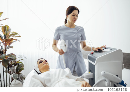 Portrait of relaxed young female client getting SMAS ultrasound face lifting massage 105168158