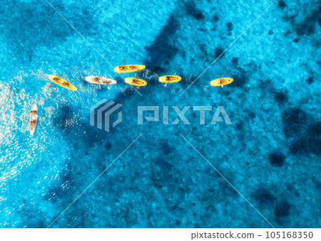 Aerial view of yellow kayaks in blue sea at sunset in summer 105168350