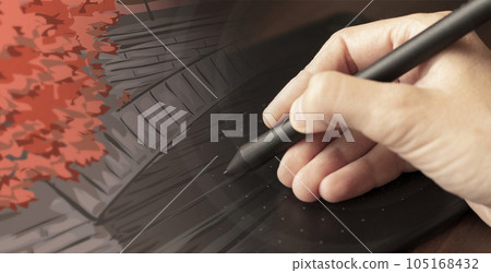 A hand draws with a stylus on a graphics tablet 105168432