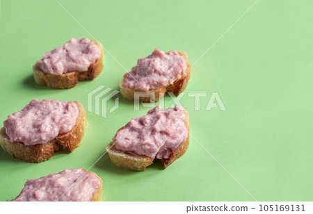 Crostini with tarama or taramasalata canape isolated on the green background Crostini with tarama or taramasalata canape isolated on the green background 105169131