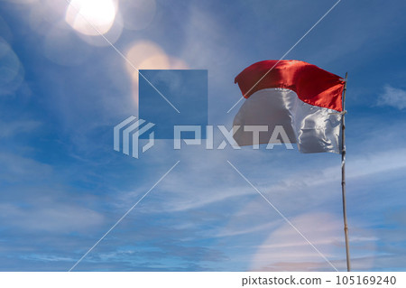 Flag of the republic indonesia with blue sky as background. indonesia flags under blue sky independence day concept Flag of the republic indonesia with blue sky as background. indonesia flags under blue sky independence day concept 105169240