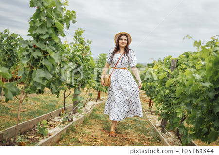Young enchanting woman in summer sundress with floral pattern Young enchanting woman in summer sundress with floral pattern 105169344