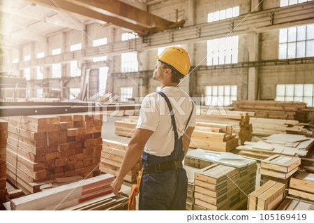 Male worker standing by construction materials in building 105169419