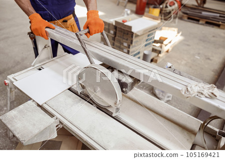 Male worker using sawing machine in workshop 105169421