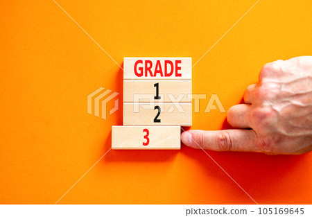 Time to grade 3 symbol. Concept word Grade 1 2 3 on wooden block. Businessman hand. Beautiful orange table orange background. Business planning and time to grade 3 concept. Copy space. Time to grade 3 symbol. Concept word Grade 1 2 3 on wooden block. Businessman hand. Beautiful orange table orange background. Business planning and time to grade 3 concept. Copy space. 105169645