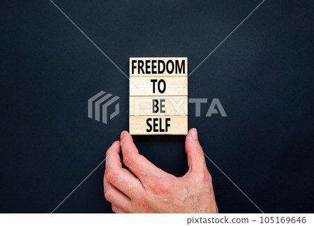 Freedom to be self symbol. Concept words Freedom to be self on wooden blocks on a beautiful black table black background. Businessman hand. Business, psychological freedom to be self concept. Freedom to be self symbol. Concept words Freedom to be self on wooden blocks on a beautiful black table black background. Businessman hand. Business, psychological freedom to be self concept. 105169646