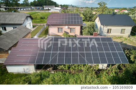 Photovoltaic solar panel fading away and shifting into metal supporting structure. Transition between metal rails and solar modules on roof of house. Concept of alternative energy sources. Aerial view 105169809