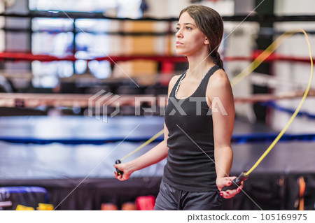 Jumping rope warm up. Sportswoman fitness training working out in boxing gym. Hispanic young woman 105169975
