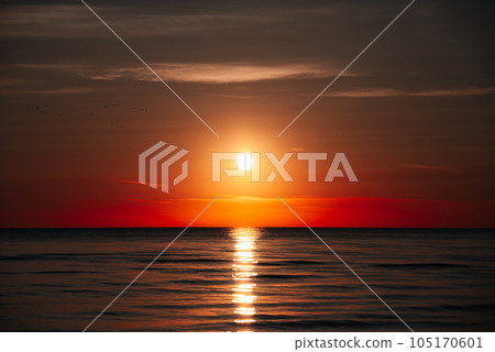 Rays Of Rising Sun Create Golden Sheen On The Water Surface Of Ocean, As If Ocean Becomes Crystal And Noble. Sunrise On Beach Symbolizes Beginning Of New Day, Hope And Awakening Of Nature To Life. 105170601