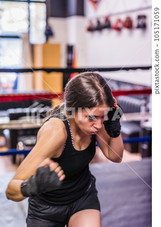 K1 mixed martial arts, Hispanic young woman fighter doing aerobox for cardio. Power strengh action 105171059