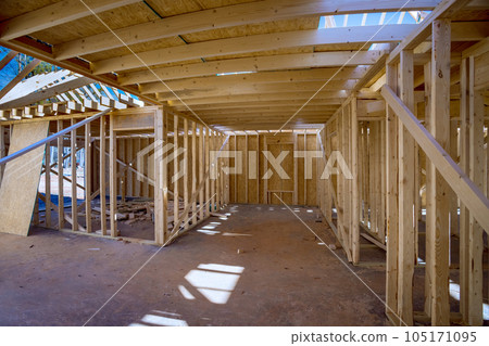 In course of construction, support beams are being constructed along with wooden framework frame for house 105171095