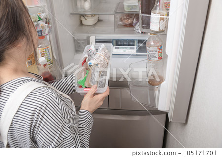 [A housewife takes out a tray from the refrigerator] 105171701