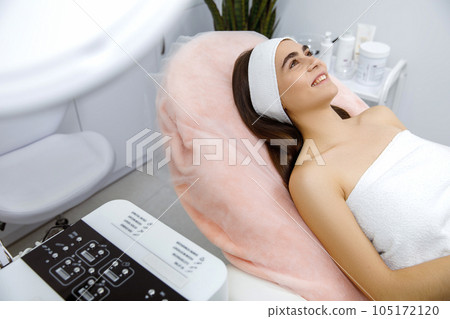 Cosmetic procedure, Beauty Skin Care, Facial rejuvenation treatment, cosmetic manipulation. smiling young woman at the beautician's procedure 105172120