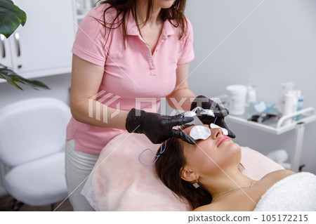 Facial rejuvenation, Dermatology Services, Beauty Skin Care, Cotton pads on the eyes, preparation for a cosmetic procedure. doctor performs a rejuvenation procedure for a woman. IPL procedure 105172215