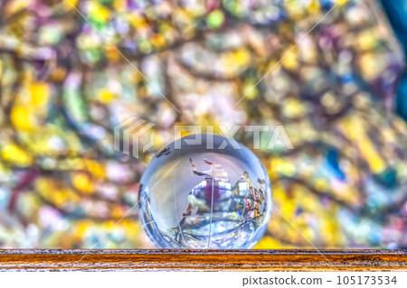 Crystal globe in front of colorful stained glass 105173534
