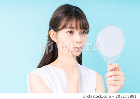 young woman thinking in the mirror 105173991