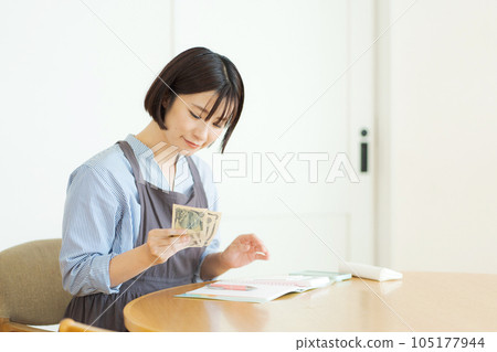 Woman counting bills 105177944