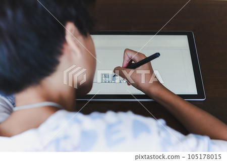Closeup young school boy with stylus pen writing on digital notepad. Closeup young school boy with stylus pen writing on digital notepad. 105178015