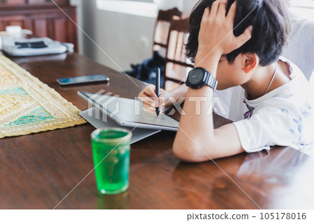 School boy with stylus pen writing on digital notepad. School boy with stylus pen writing on digital notepad. 105178016