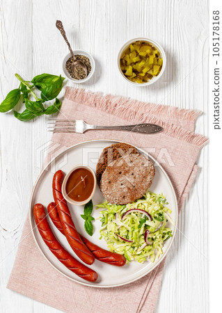 sausages with coleslaw salad, bbq sauce on plate sausages with coleslaw salad, bbq sauce on plate 105178168