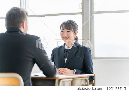 A teacher and a smiling Asian high school student who conducts career counseling, two-way interviews, and interview practice at school about the school of choice 105178745