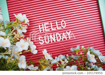 Hello Sunday text on Letter Board with flower decoration 105178950