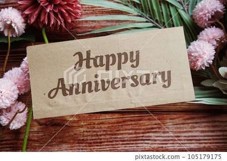 Happy Anniversary text message with flower decoration on wooden background 105179175